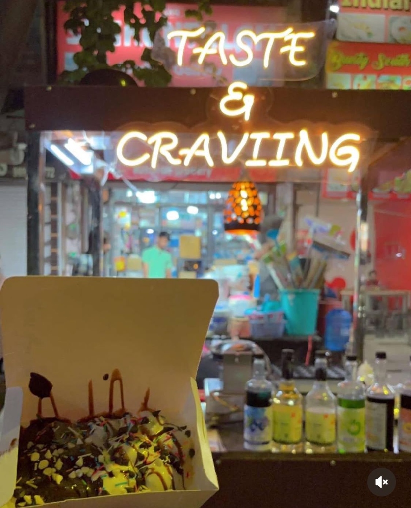Taste & Craviing street hub with neon sign and fresh dessert box
